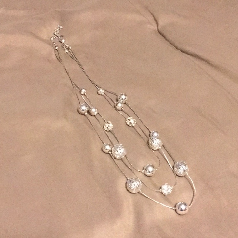 Triple strand silver necklace with silver beads.